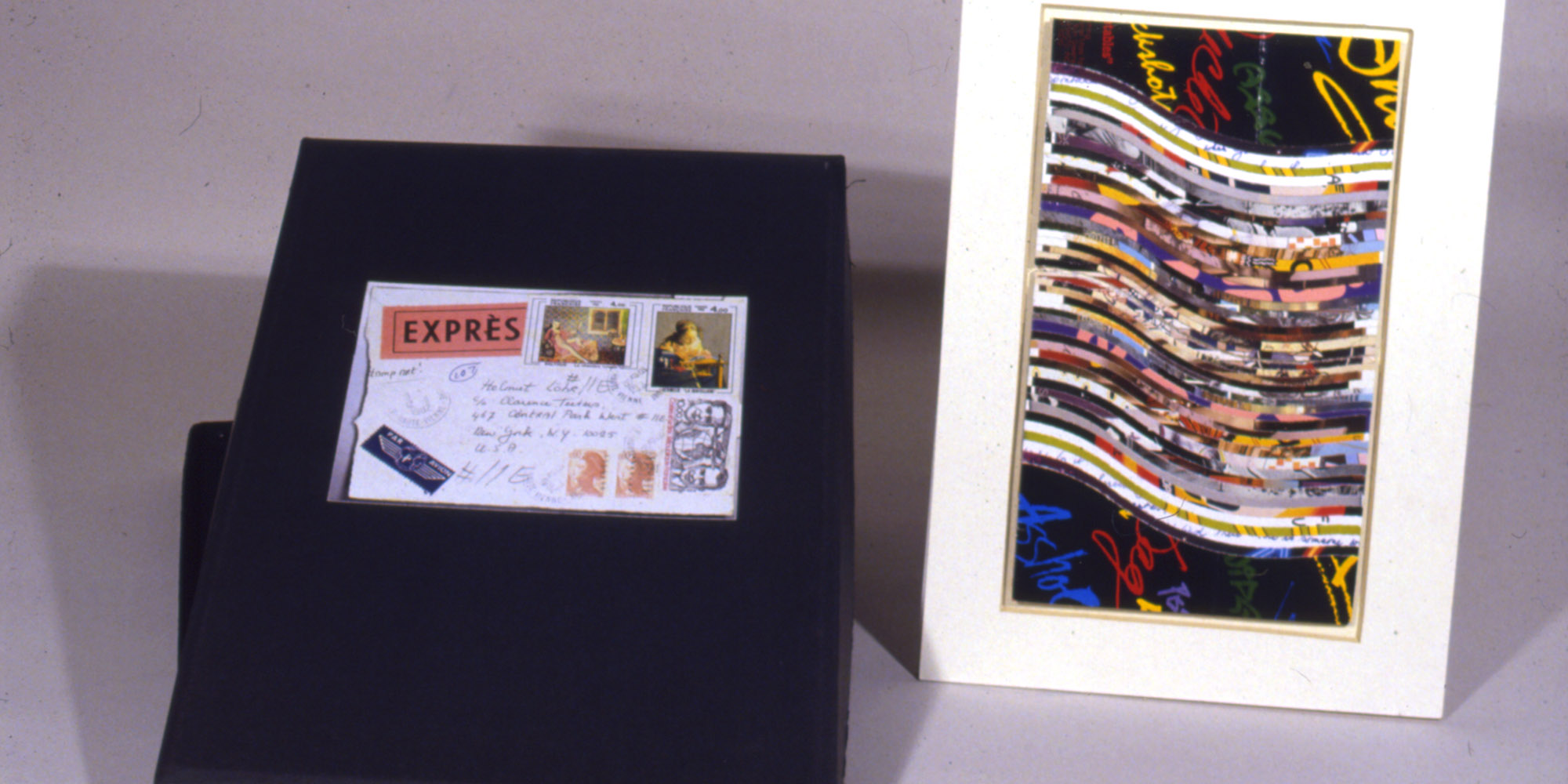 A banner showing a what appears to be a black box with a lid. The box contains an addressed envelope with multiple stamps. An artwork stands propped up to the right of the box, showing a collage like work of multi colored wavy lines.